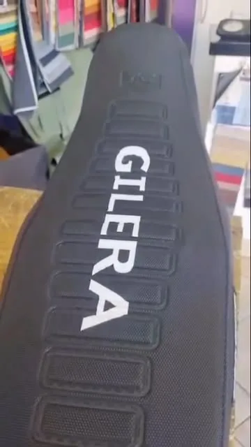 Asiento de moto Gilera tapizado en negro con letras blancas